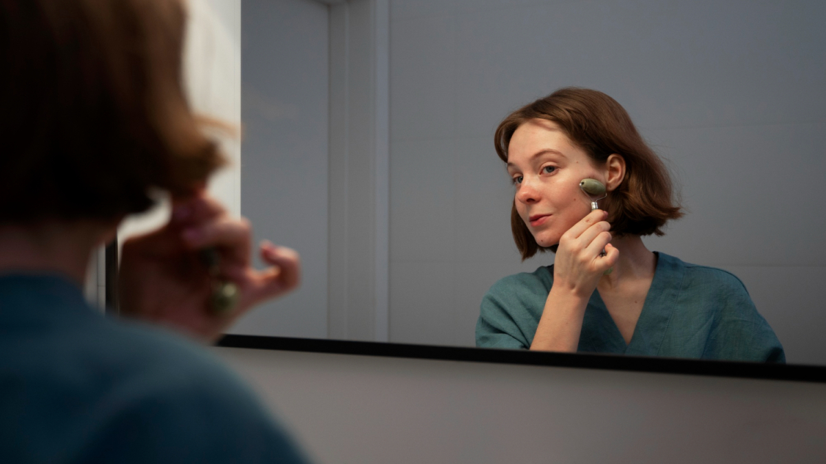 Женщина массирует лицо роликом