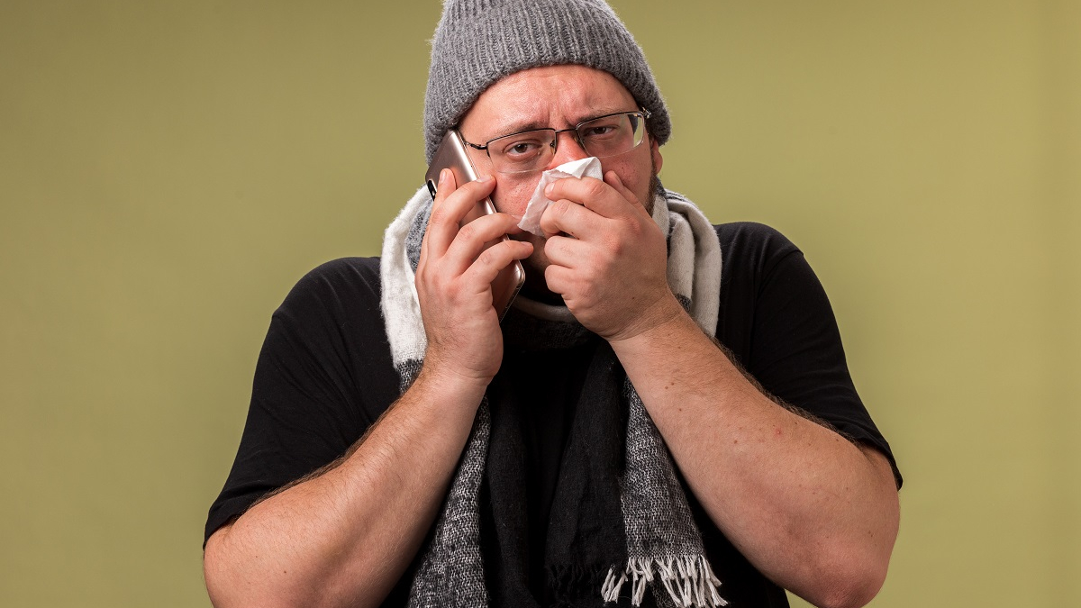 мужчина чихает в платок