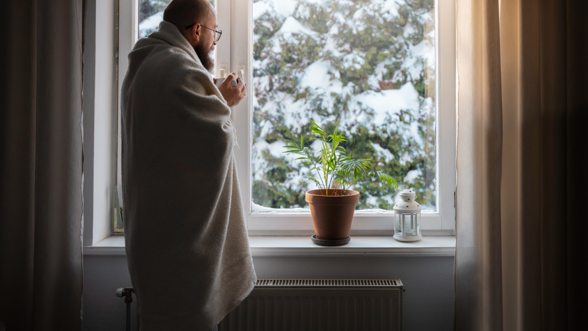 Мужчина стоит возле окна