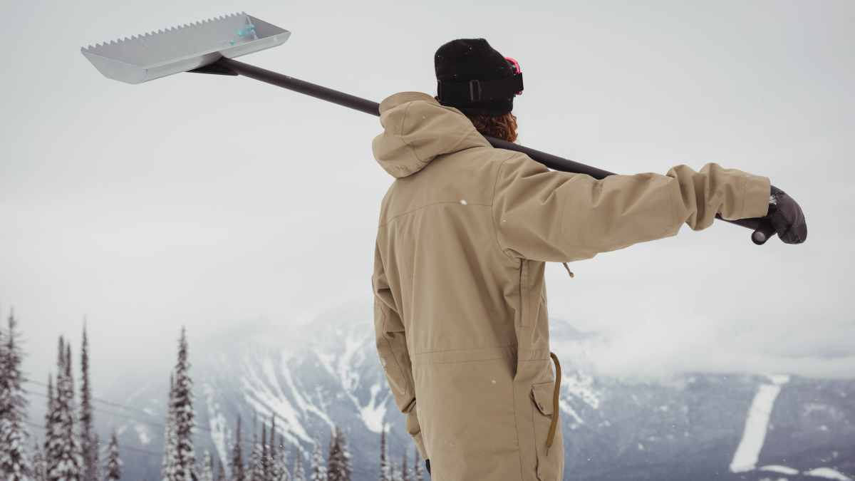 Мужчина с инструментом для чистки снега