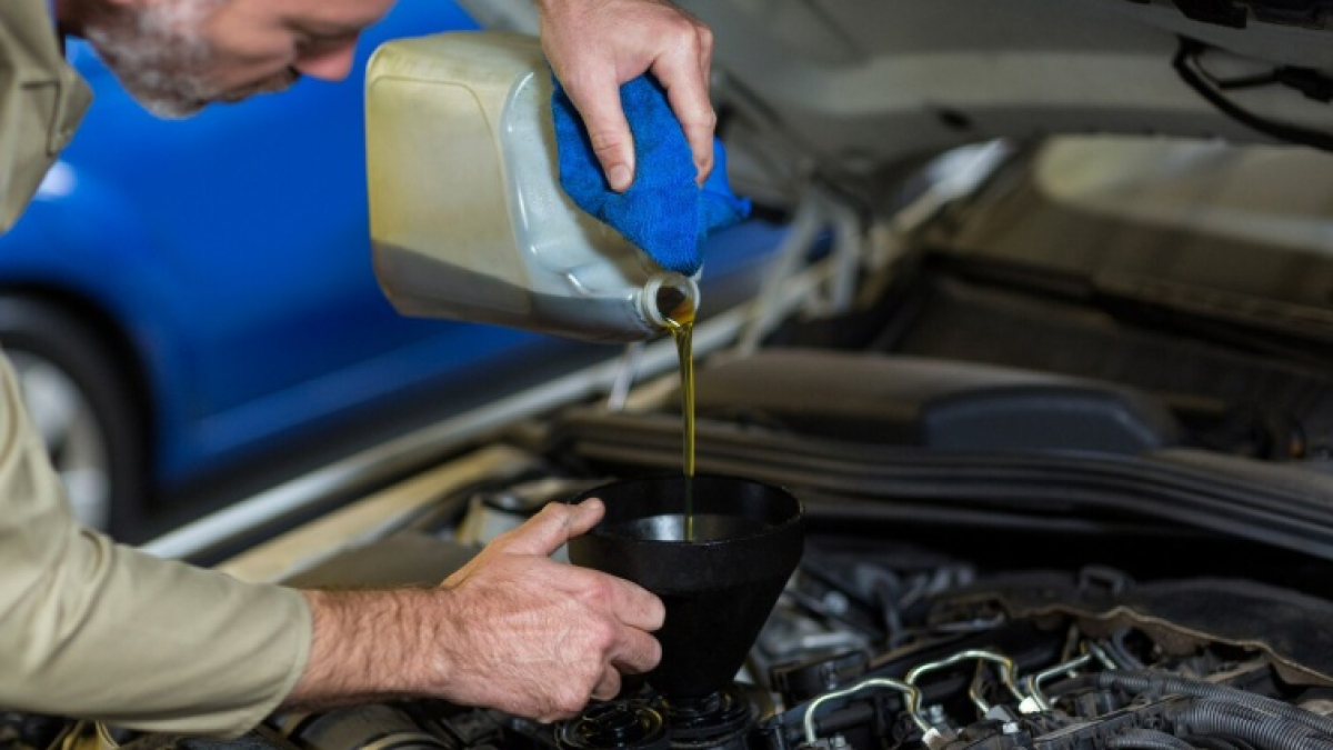 мужчина заливает масло