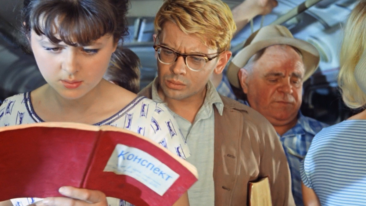 Молодой человек заглядывает в конспект девушке