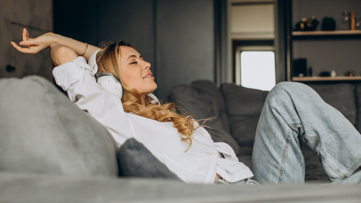 Девушка потягивается, отдыхая дома на диване,