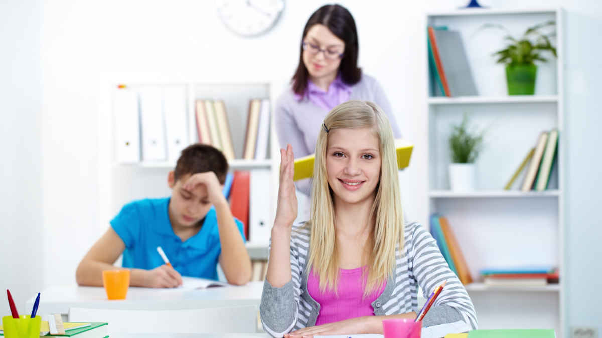 Девочка поднимает руку в классе