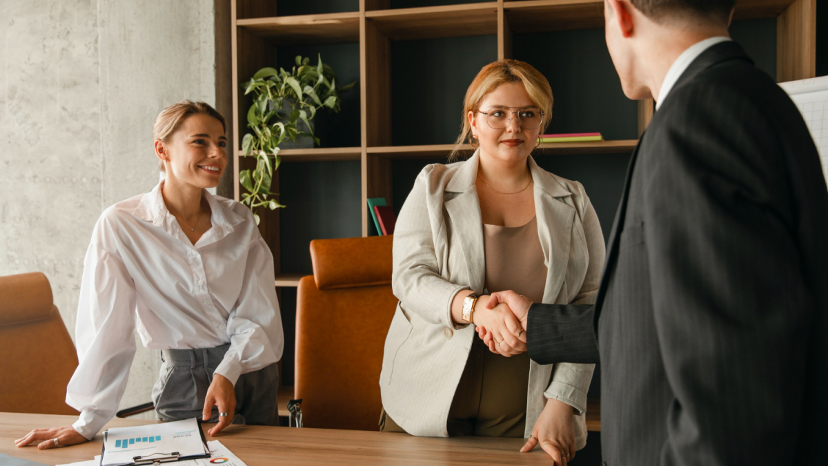 Женщина пожимает руку мужчине в костюме