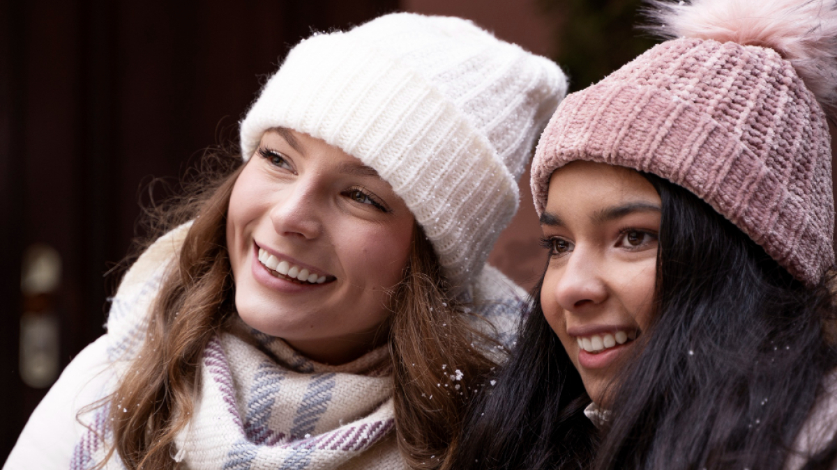 Две девушки в теплых шапках зимой на улице