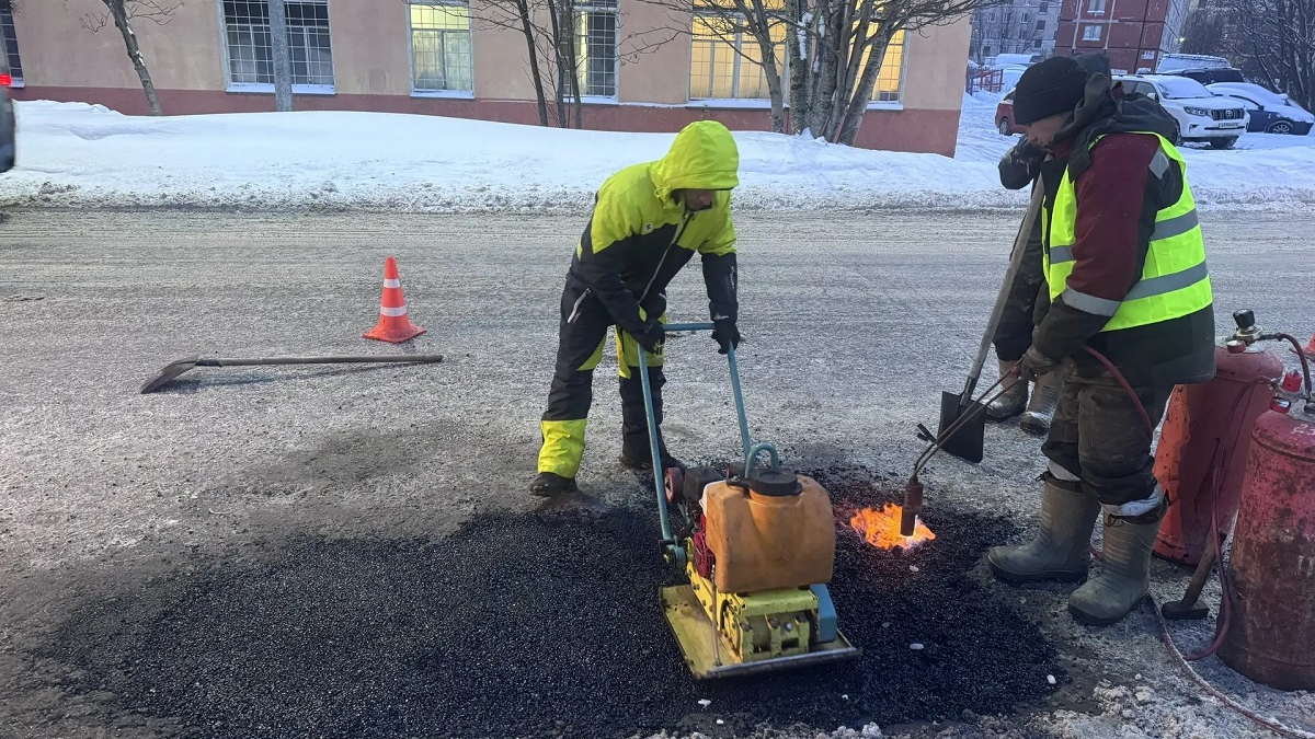 дорожники зимой ремонтируют асфальтовое покрытие
