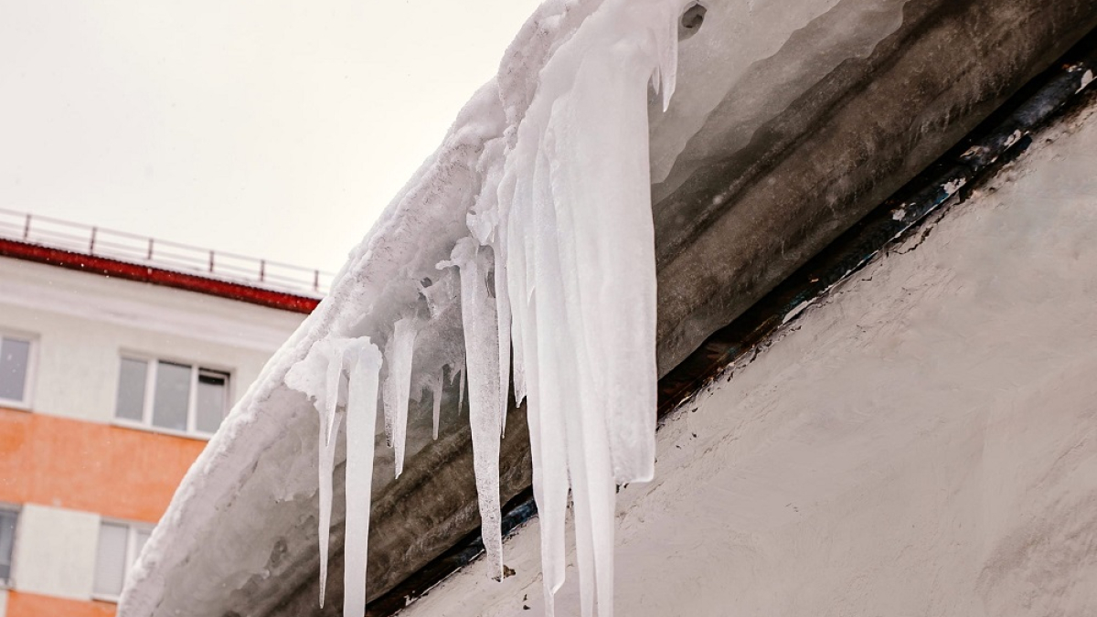сосульки свисают с крыши дома