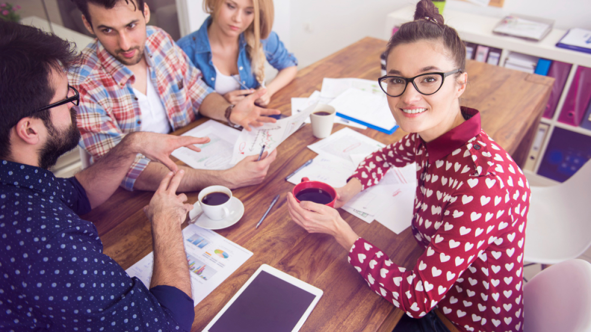 Люди сидят за столом с бумагами и обсуждают проект