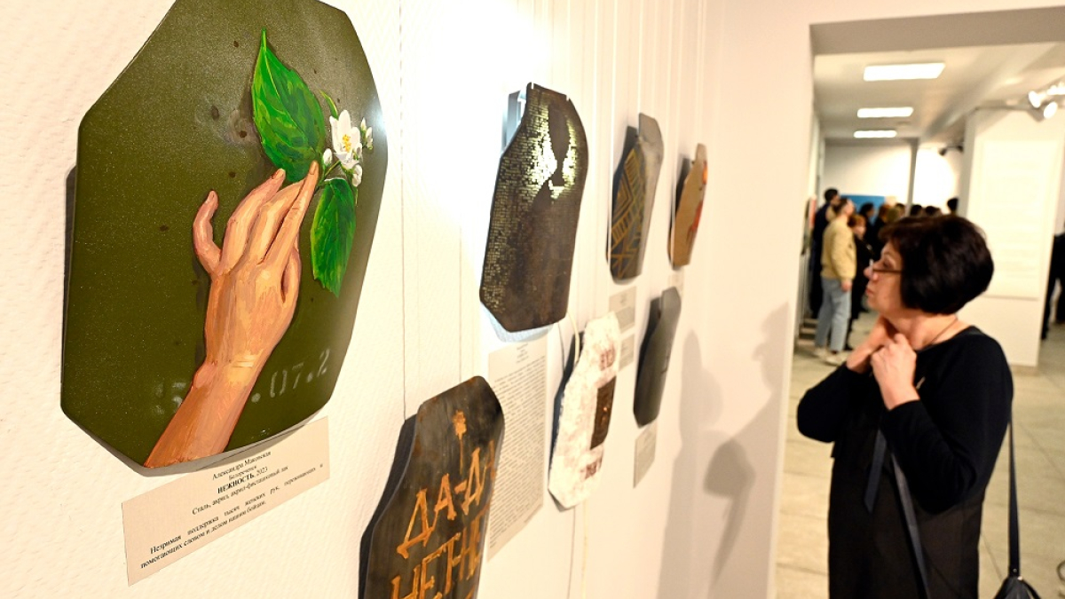 женщина смотрит картины на выставке