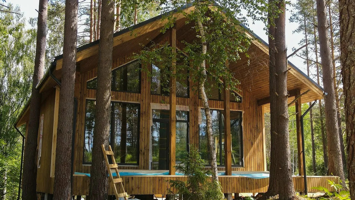 Каркасный дом среди деревьев