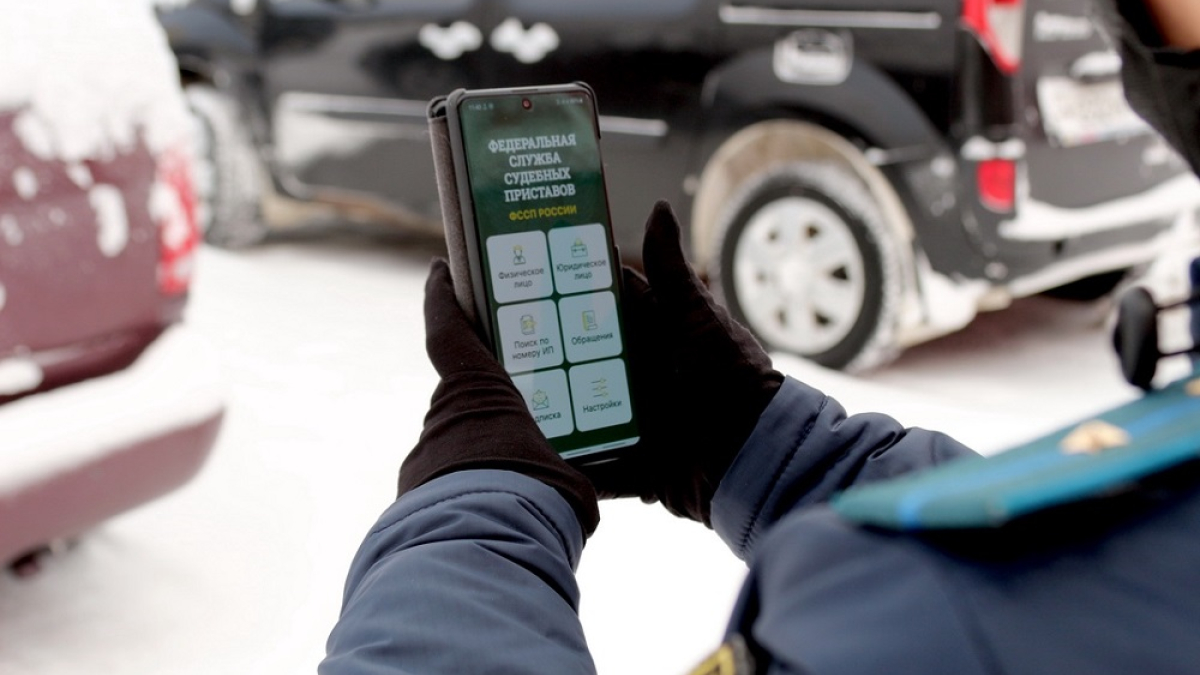 судебный пристав смотрит в телефон