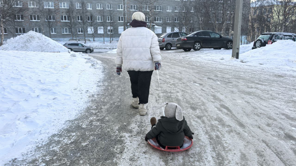 Ребёнка катают на санках
