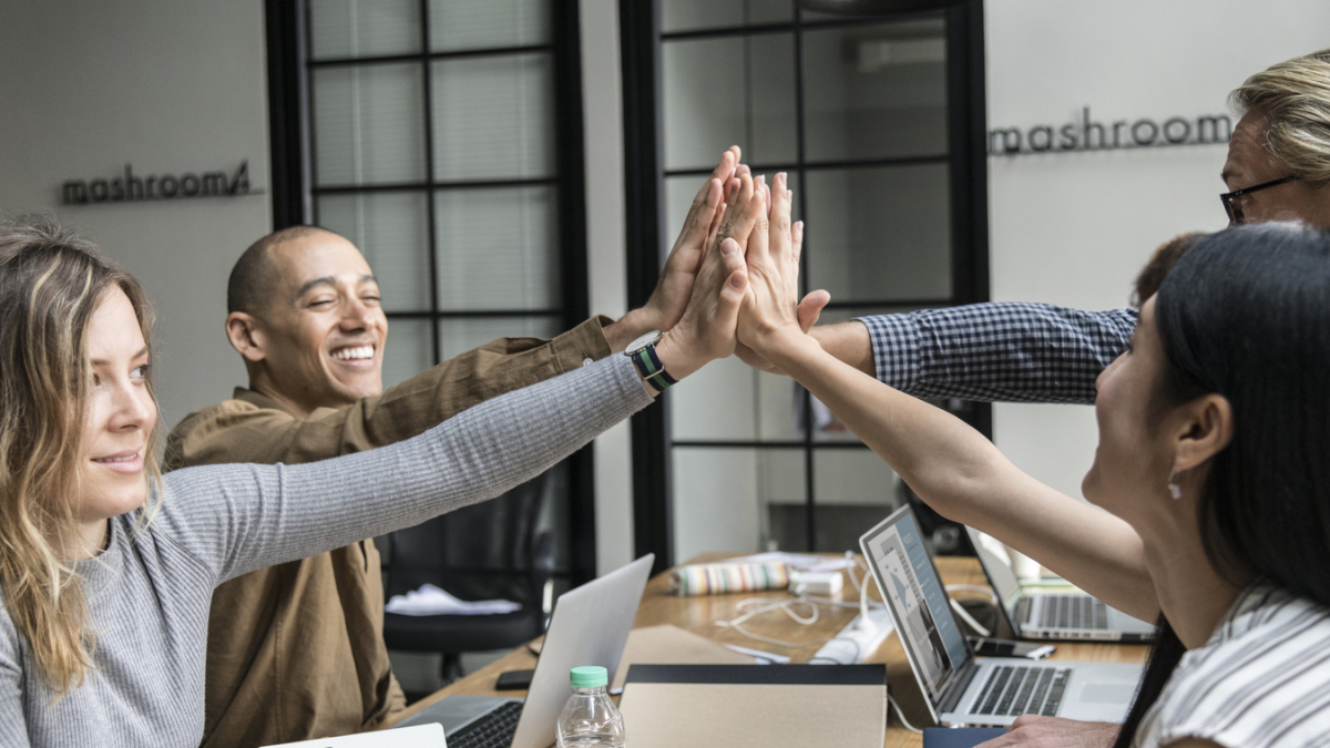 Люди соприкасаются ладонями за столом