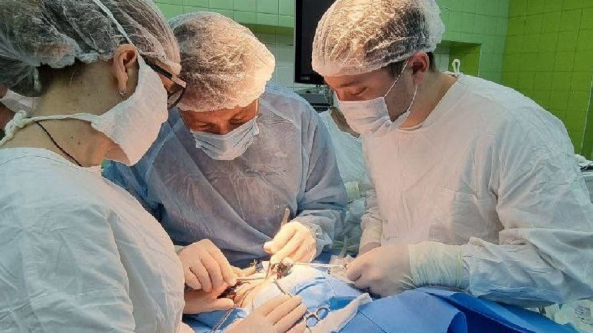 бригада хирургов проводит операцию