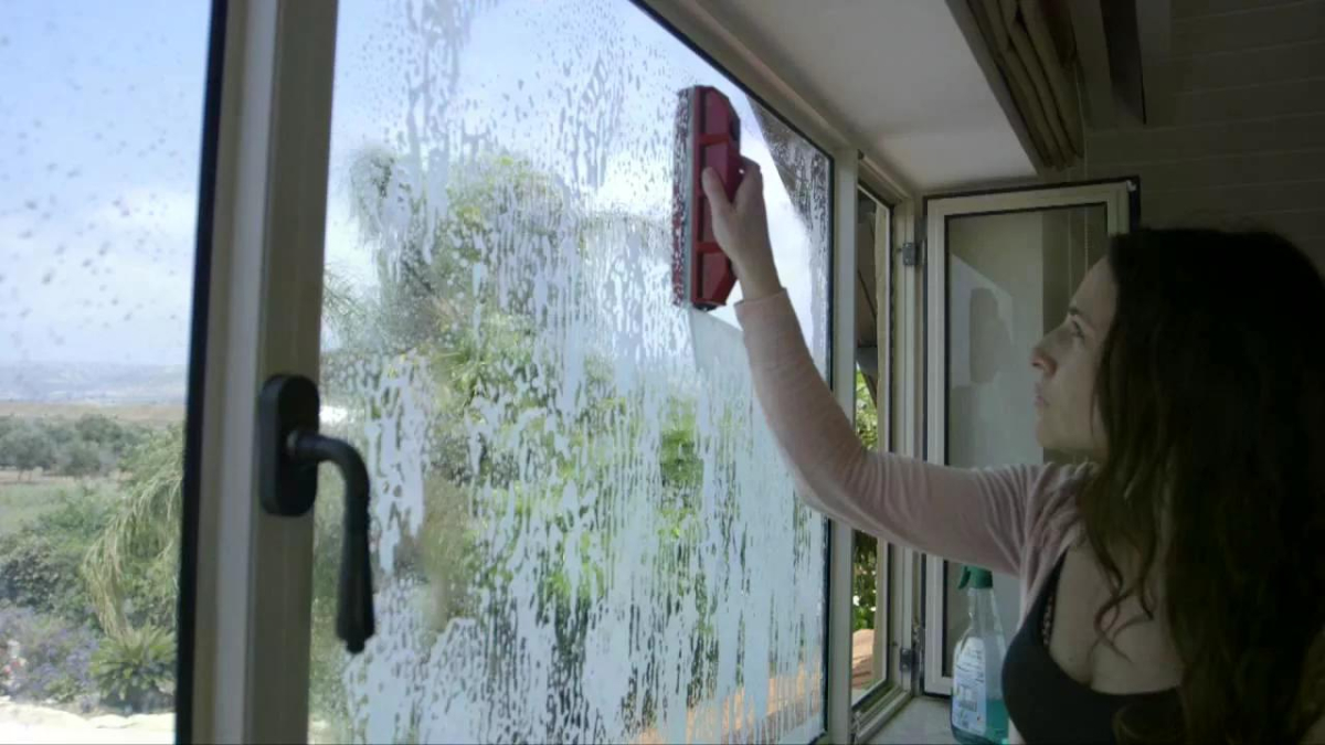 Женщина моет окна