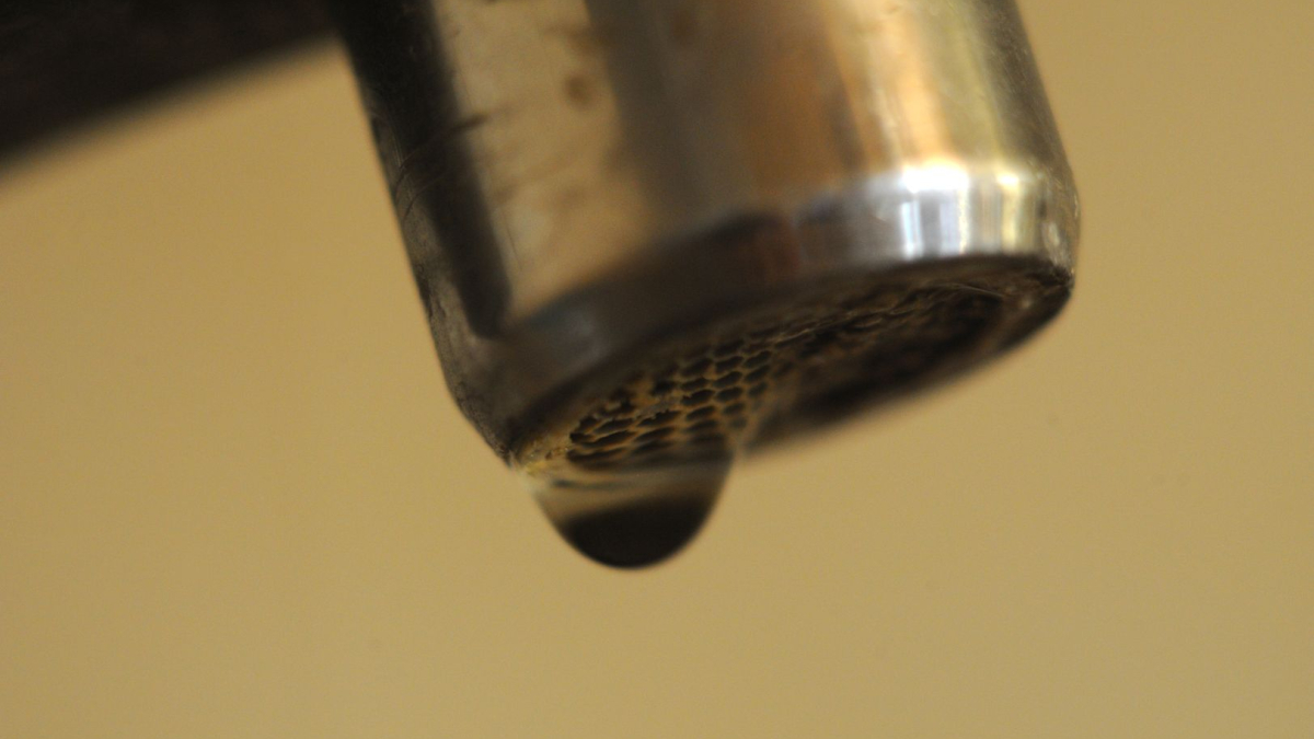 Черный кран с каплей воды