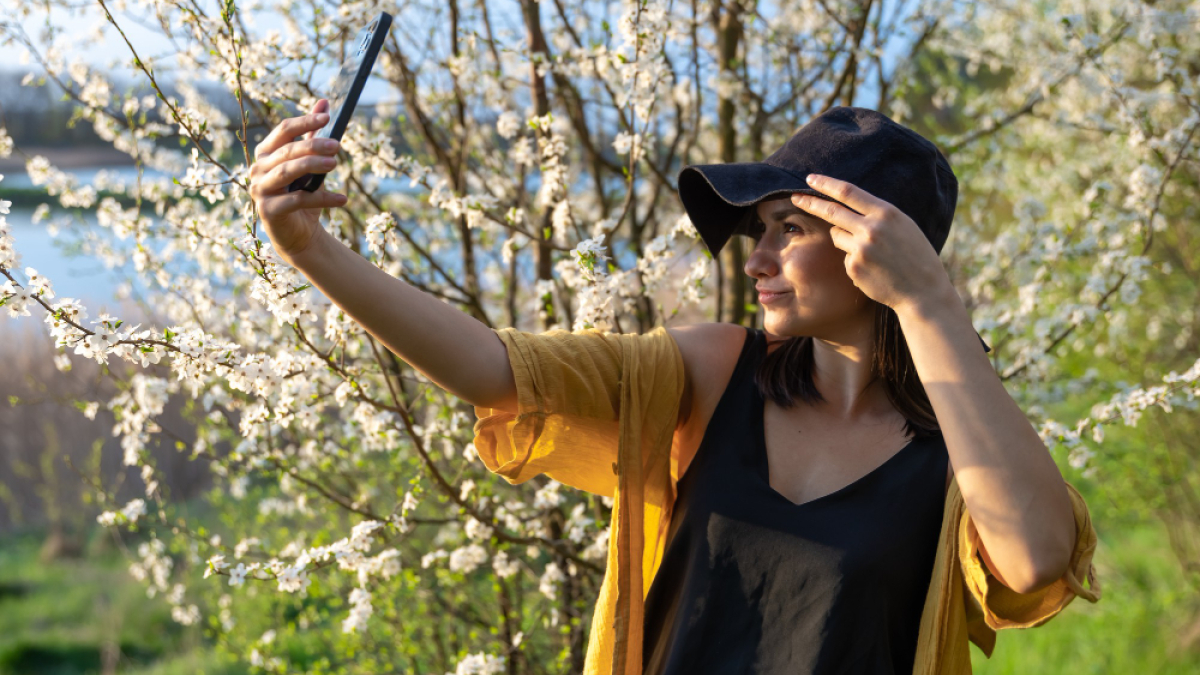 Девушка весной на улице делает селфи.