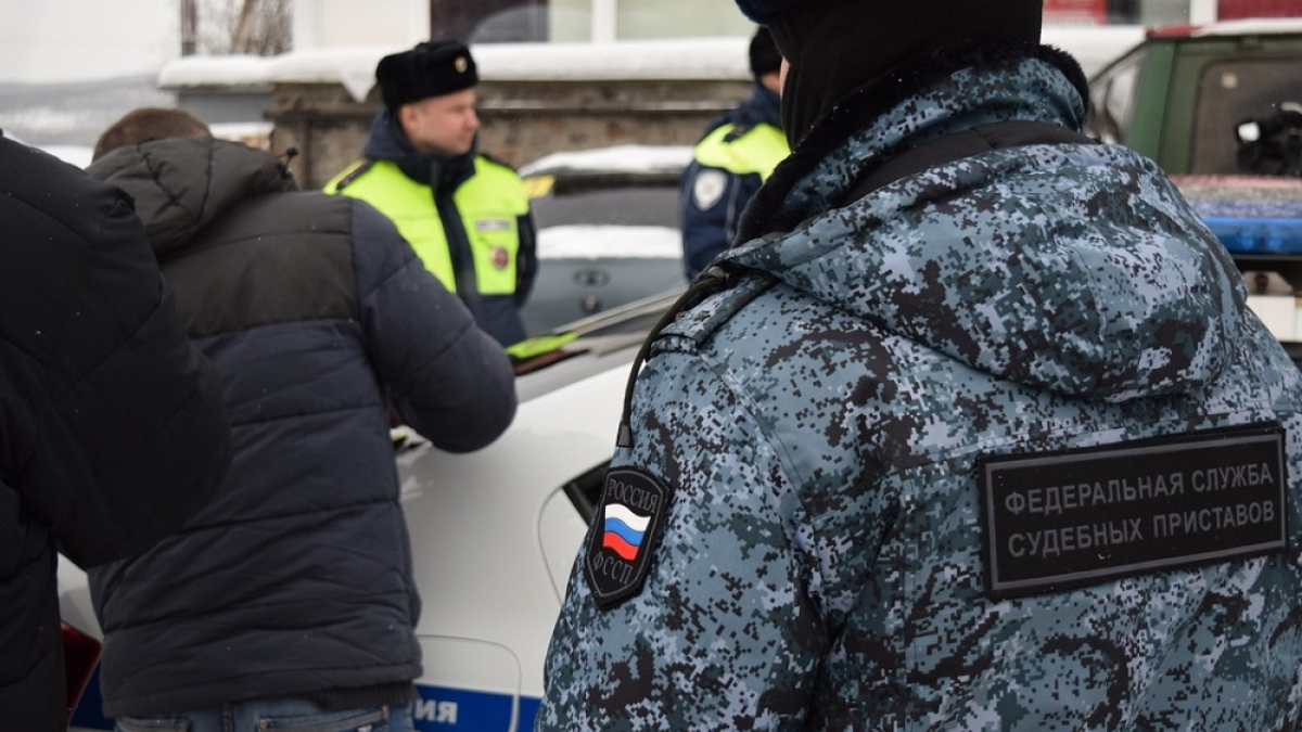 приставы на улице разговаривают с мужчиной