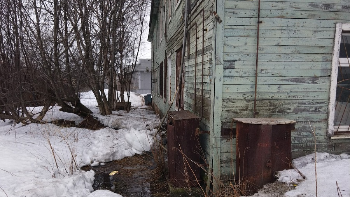 лужа возле старого деревянного дома