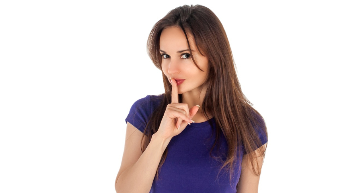 Девушка прижимает палец ко рту