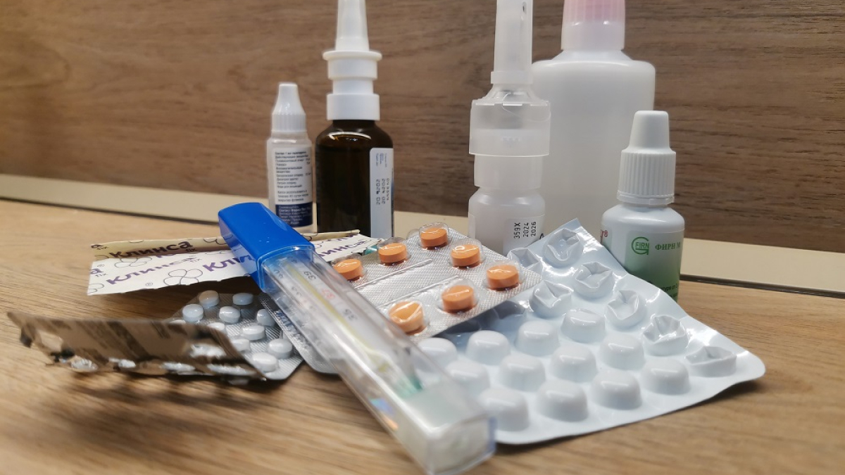 лекарства и градусник на столе