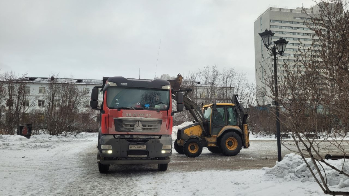 Грузовики грузят снег