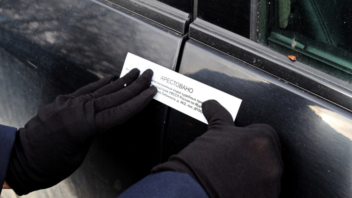 пристав опечатывает автомобиль