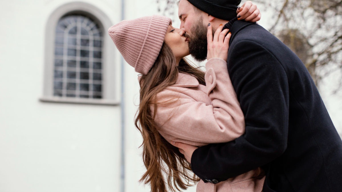 Влюбленная пара целуется на улице.