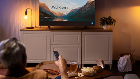 Человек смотрит передачу на телевизоре