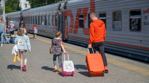 Семья с детьми отправляется в отпуск на поезде