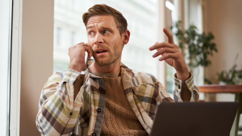 Мужчина держит в руках телефон