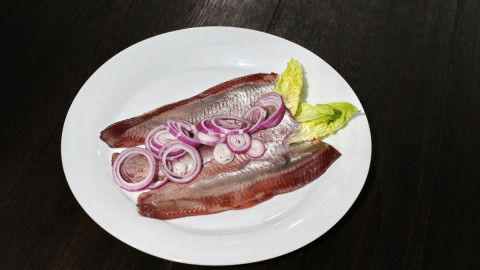 Селедка с луком на тарелке