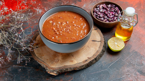 на столе тарелка фасолевого супа и бобовые