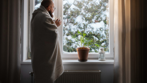 Мужчина стоит возле окна