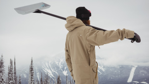 Мужчина с инструментом для чистки снега