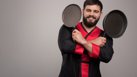 Человек держит две сковороды