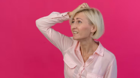 Женщина держится за голову