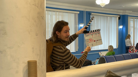 мужчина держит кинематографическую рамку