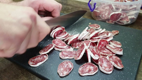 Женщина режет колбасу фуэт