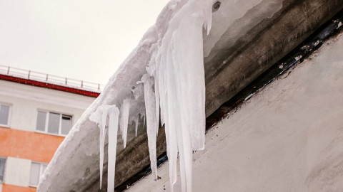 сосульки свисают с крыши дома