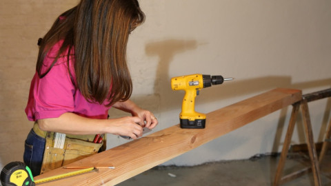 Женщина во время ремонта собирается что-то сверлить