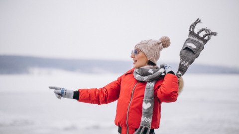 Девушка в красной куртке бежит на фоне зимнего пейзажа