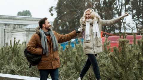 Парень держит за руку идущую по бордюру девушку