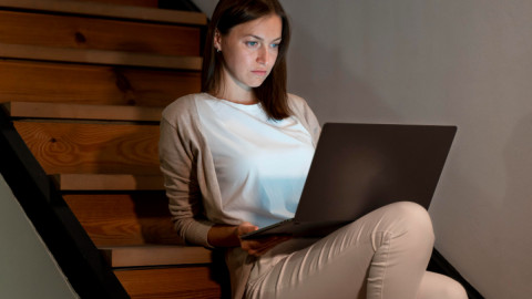 Девушка за компьютером в тени