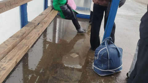 люди стоят в остановочном павильоне