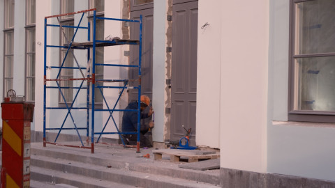 Строитель выравнивает стену