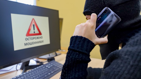 мошенник разговаривает по телефону