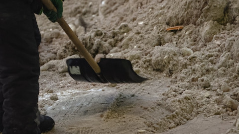 мужчина лопатой чистит снег