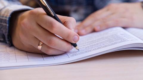 мужчина пишет ручкой на бумаге